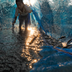 A boy checks on his captive mud carp. He sells them after a week when they are more valuable than others’ dried fish.